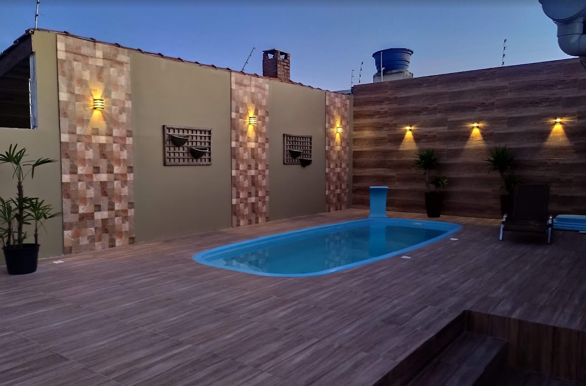 Área externa com piscina, revestimentos e iluminação executada pela Edificar